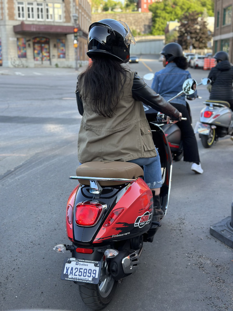 vue de trois conductrices de Vespa à une intersection au coeur de Québec