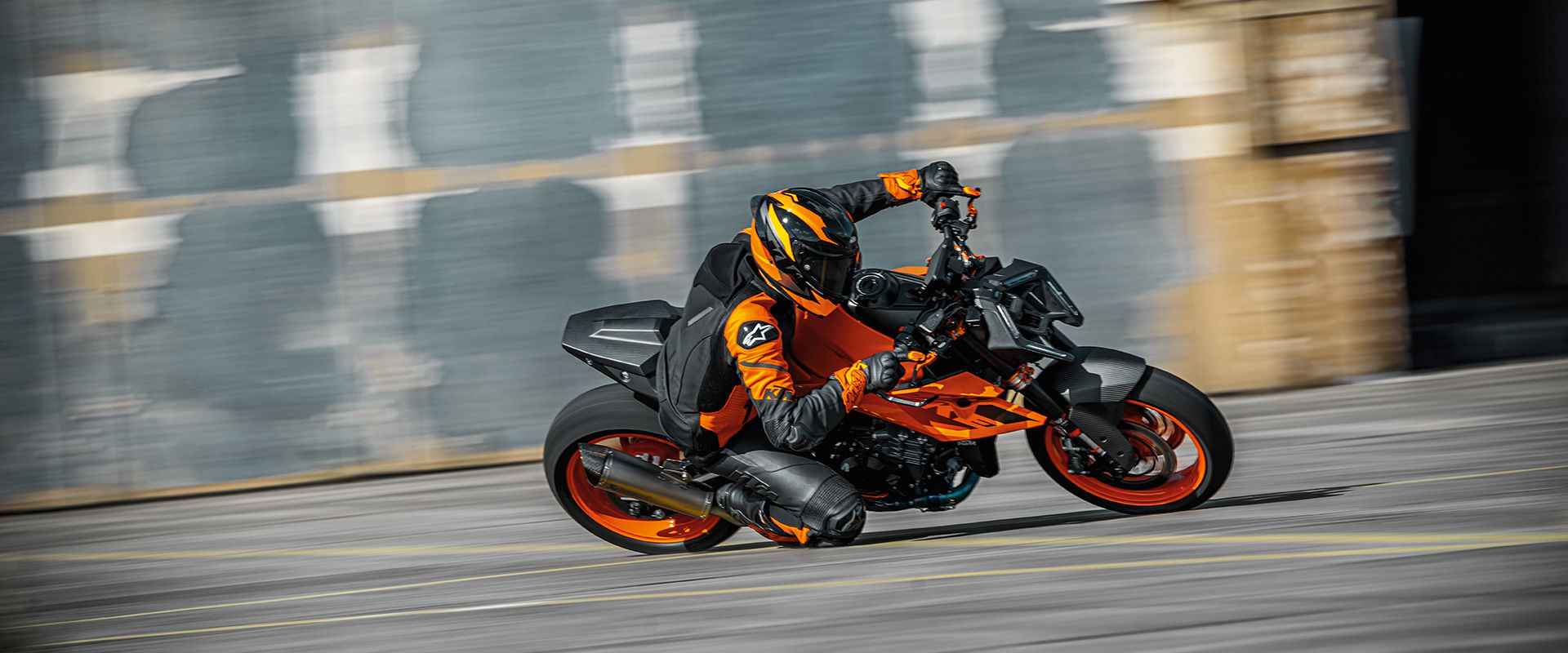 front side view of a 2024 KTM Duke 990 and its driver during a sharp turn on a race track