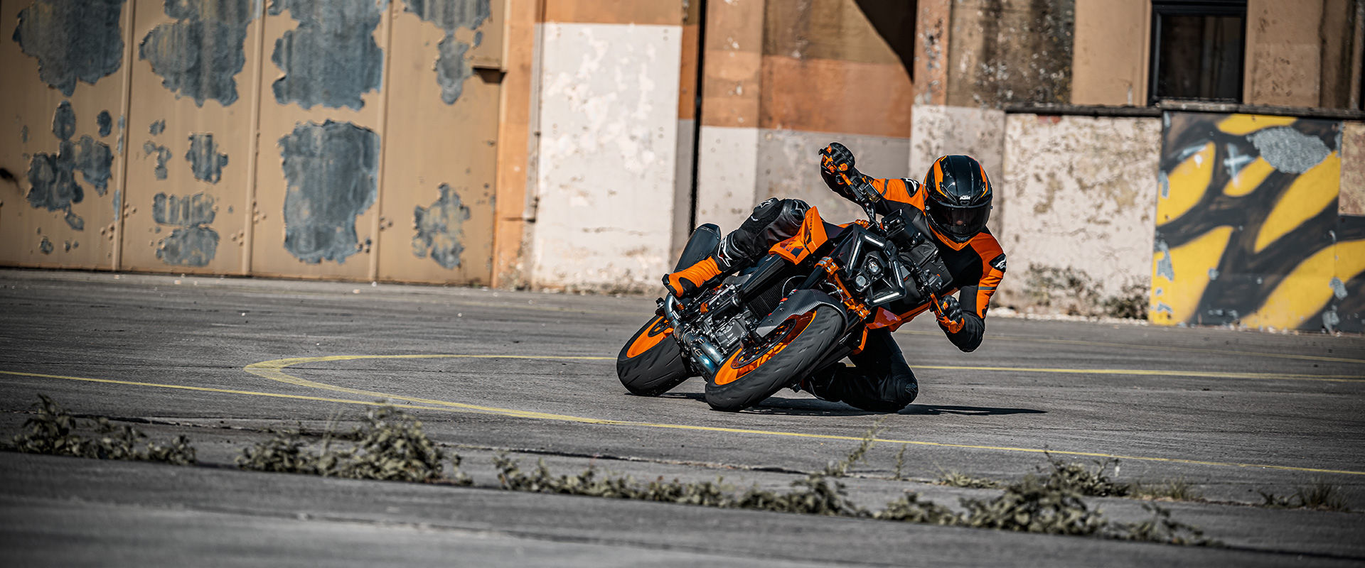 front side view of a 2024 KTM Duke 990 and its driver on a race track