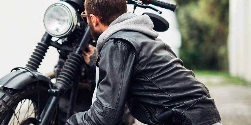 Motorcyclist examining his motorcycle.